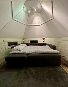尤卡斯耶尔维Camp Caroli Hobbit Hut的一张位于带大型天花板的房间内的床铺