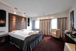 里加塔林酒店的配有一张床和一张书桌的酒店客房