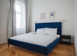 维也纳Brand Cozy Apartment的一张带蓝色床头板的睡床