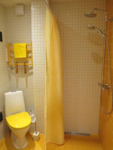 派尔努家庭度假公寓的浴室设有淋浴、卫生间和黄色的淋浴帘