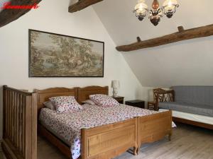 Lussault-sur-LoireClos Lussault - 4 gîtes, separate or together的卧室配有一张床,墙上挂有绘画作品