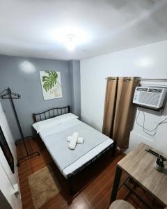 独鲁万Studio type unit - Host Homes Apitong的小房间设有一张床和空调
