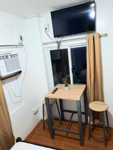 独鲁万Studio type unit - Host Homes Apitong的墙上有电视的小桌子