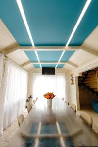 KrasnikВілла у горах的一间设有桌子和蓝色天花板的用餐室