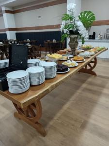 帕图布兰库HOTEL MAESTRO EXECUTIVE PATO BRANCO的一张木桌,上面放着食物盘