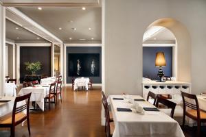 巴塞罗那康达多酒店的一间设有白色桌椅的用餐室