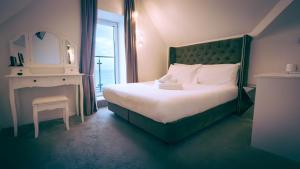 纽基OYO Newquay Beach Hotel的一间卧室配有一张床、一张桌子和一面镜子