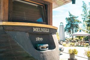 梅恩塞尔斯Viesu nams Melnsils的一间燃木餐厅,上面标有meerkats的标志