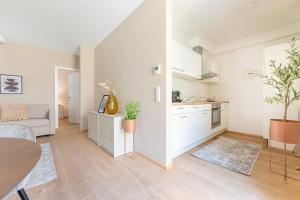多瑙河畔克雷姆斯Garden.Suite am Steinertor的白色的公寓设有一间厨房和一个客厅。