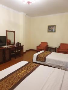 胡志明市Ngọc Lan Hotel的一间卧室配有两张床、一张桌子和一面镜子