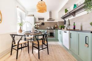韦灵厄Fully Equipped Apartment Close to Malmö & Copenhagen的厨房配有绿色橱柜和桌椅