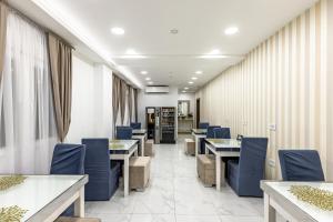 贝尔格莱德ForS Resort & Spa的一间配备有蓝色椅子和桌子的用餐室