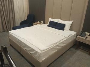 埃尔比勒达林广场酒店 的卧室配有带蓝色枕头的大型白色床