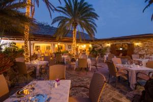 英吉利港英国港酒店的餐厅拥有白色的桌椅和棕榈树
