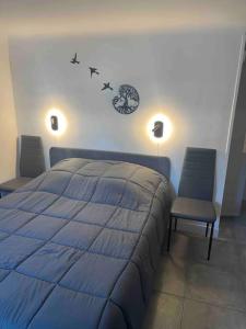 塞夫朗Chez Pascal et Sonia au calme !的一间卧室配有蓝色的床和两把椅子