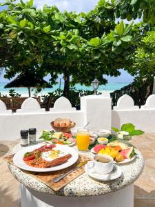 马特姆维桑给巴尔度假酒店 的餐桌上的早餐桌,包括食物和饮料