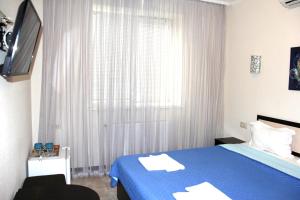 敖德萨布瑞姿酒店的一间卧室设有蓝色的床和窗户。