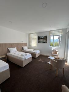 比耶洛波列Naš Dom Hotel的一间卧室配有两张床、一张沙发和一把椅子
