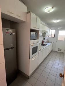 科皮亚波Exclusivo y cómodo departamento的厨房配有冰箱和炉灶。 顶部烤箱