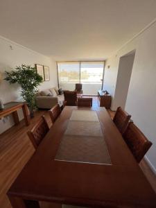 科皮亚波Exclusivo y cómodo departamento的客厅配有大型木桌和椅子