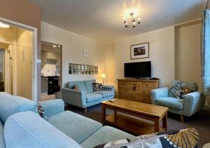 巴茅思Luxury 4 Bedroom Seaside Apartment - Glan Y Werydd House的客厅配有蓝色的沙发和电视