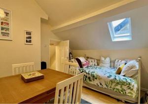 巴茅思Luxury 4 Bedroom Seaside Apartment - Glan Y Werydd House的一间卧室配有一张床、一张桌子和一个窗户。
