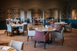 利文赫斯斯托克纳尔昂德酒店、高尔夫球和Spa的配有桌椅的用餐室