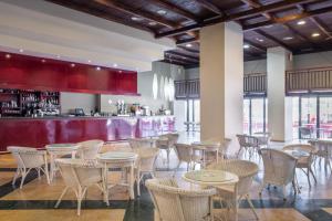 滨海罗克塔斯ALEGRIA Colonial Mar的一间带桌椅的餐厅和一间酒吧