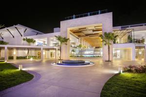 蓬塔卡纳Serenade Punta Cana Beach & Spa Resort的一座大型建筑,在晚上前方有一个喷泉