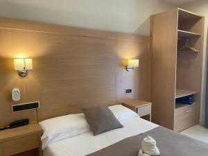 巴塞罗那坎东酒店的卧室配有白色的床和木制床头板