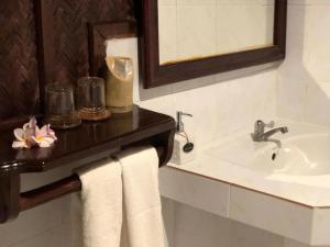 北宾湄公河河畔酒店的浴室配有盥洗盆、镜子和毛巾