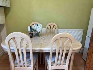 罗奇代尔Cosy 2 Bed House in Rochdale的餐桌,带两把椅子和花瓶