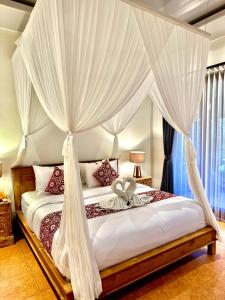 乌布PONDOK KUNGKANG VILLA 2的卧室配有带白色窗帘的天蓬床