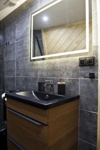 扎科帕内Góralski Harem Osada Glamp Jacuzzi & Balia的浴室设有黑色水槽和镜子