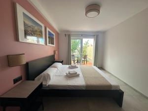 德尔锡伦西奥海岸Villa 8 Islas的一间卧室配有一张床、一张桌子和一个窗户。
