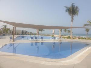 希法Beautiful Golf & Sea View的一个带椅子和棕榈树的大型游泳池