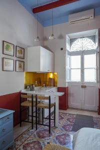 莫斯塔Malta Luxe Guest Suite Central Location的厨房配有带椅子和窗户的厨房岛