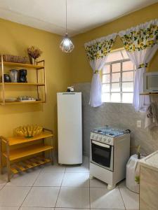 贝洛奥里藏特Aconchego Mineiro com Garagem的厨房配有冰箱和炉灶。