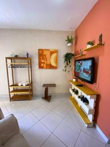贝洛奥里藏特Aconchego Mineiro com Garagem的客厅的墙上配有电视
