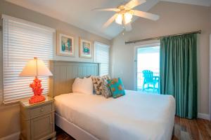 鸭礁岛Villas at Hawks Cay Resort的一间卧室配有一张带吊扇和窗户的床。
