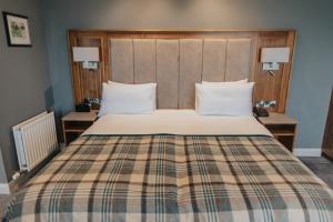 波特拉什Golflinks Hotel的一间卧室配有一张大床和一张铺着条纹毯子