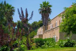 乌真托Vivosa Apulia Resort的一座棕榈树的大砖砌建筑