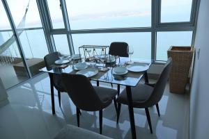 卡塔赫纳Palmetto Sunset 2903 with an amazing ocean view的窗户间配有餐桌和椅子