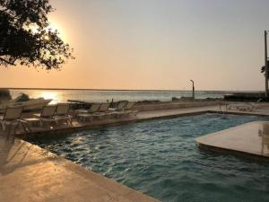 卡塔赫纳Palmetto Sunset 2903 with an amazing ocean view的一个带躺椅的游泳池和海洋