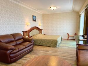 金沙Aqua View SPA Boutique Hotel的一间卧室配有一张床和一张皮沙发