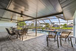 珊瑚角Direct Sailboat Access & Southern Exposure Heated Pool - Villa Coconut Hideaway - Roelens的一个带桌椅的庭院和一个游泳池