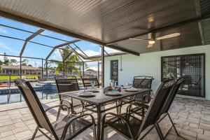 珊瑚角Direct Sailboat Access & Southern Exposure Heated Pool - Villa Coconut Hideaway - Roelens的庭院内带桌椅的用餐室