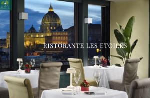 罗马亚特兰特星级酒店的一间带桌椅的餐厅,享有首都的景致。