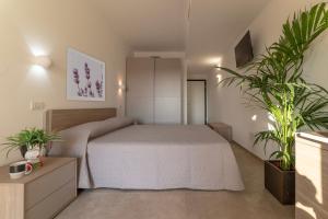 卡斯蒂里昂纳·德拉佩Casa vacanze Le Querce的一间卧室配有一张床和两盆植物