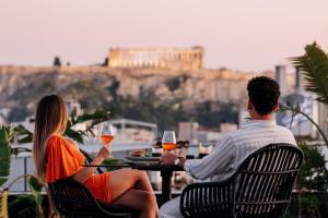雅典Skylark, Aluma Hotels & Resorts的坐在桌子上戴酒杯的男人和女人
